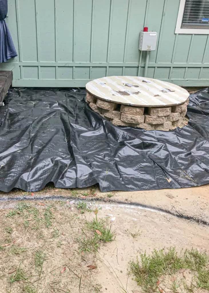 laying weed barrier in DIY gravel patio 