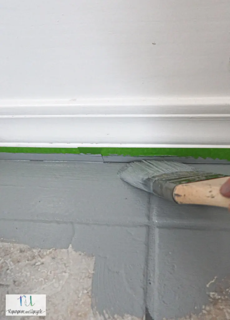 using paintbrush to cut in to the edges of the tile