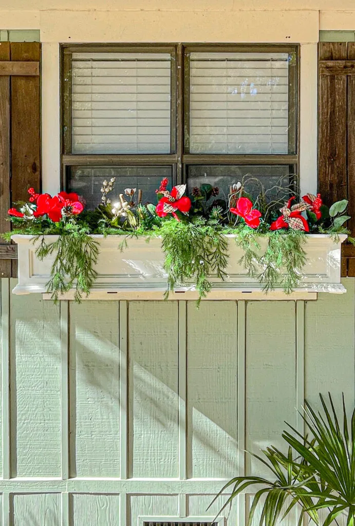 winter window box decor with faux poinsettias and amaryllis mix