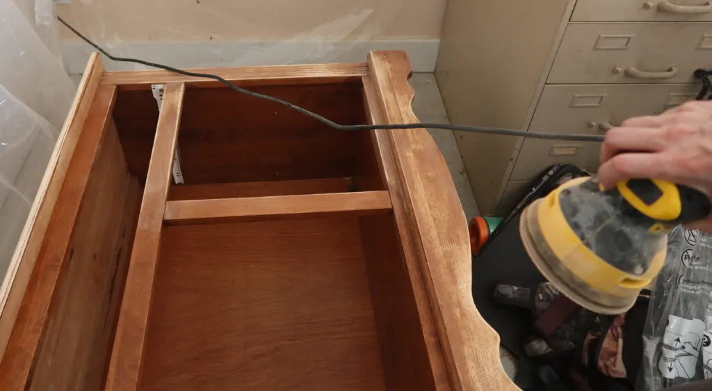 Sanding the cabinet with a palm sander