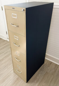 applying peel and stick wallpaper to a metal filing cabinet